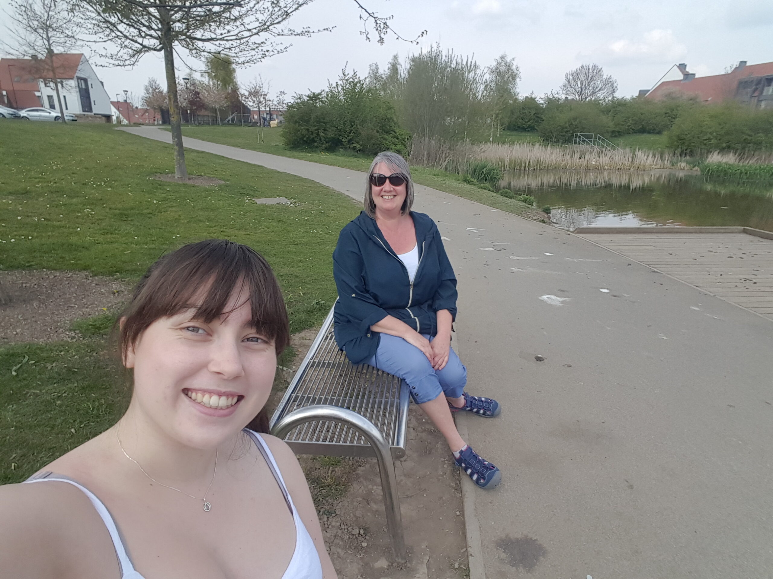 student volunteer and beneficiary sitting by a lake