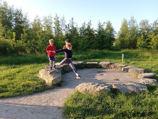 Children leaping around a stone circle